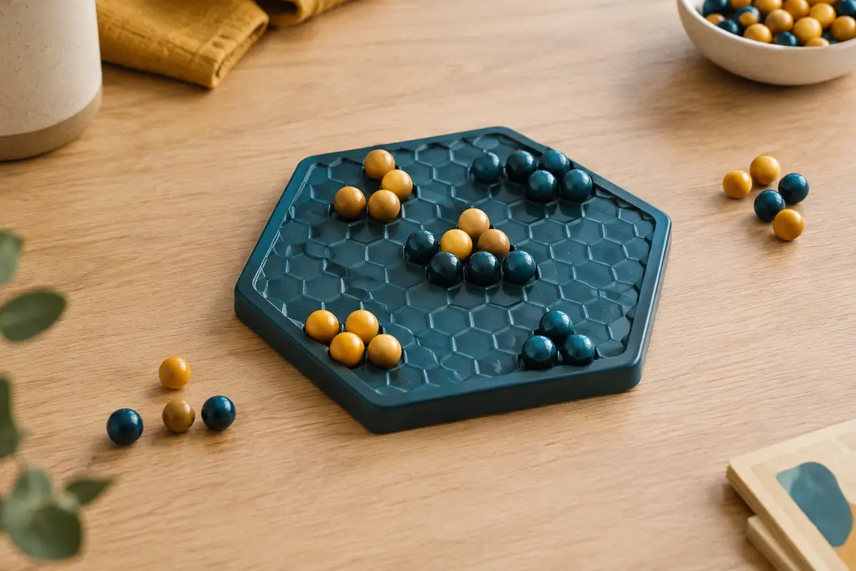 Plateau hexagonal compact avec des billes de jeu disposées en groupes sur une table en bois clair.
