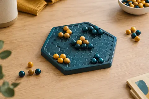 Plateau hexagonal compact avec des billes de jeu disposées en groupes sur une table en bois clair.